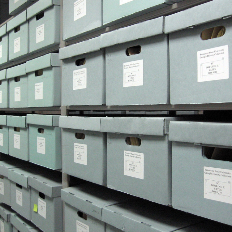 Photo of rows of blue bankers boxes stored on shelves